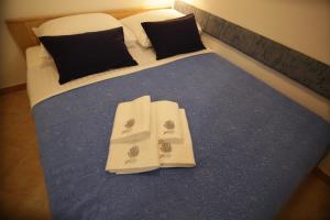 a bed with two white towels on top of it at Apartment Ljubica Tisno in Tisno