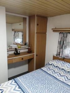 een slaapkamer met een bed, een wastafel en een spiegel bij House Camping Pasito Blanco in Maspalomas