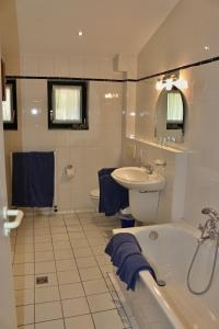 y baño con bañera, lavabo y aseo. en Ferienwohnung Fischerhütte Xanten, en Xanten