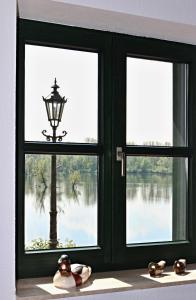 a window with a lamp and a view of a lake at Ferienwohnung Fischerhütte Xanten in Xanten