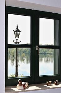 ventana con lámpara y vistas al lago en Ferienwohnung Fischerhütte Xanten, en Xanten