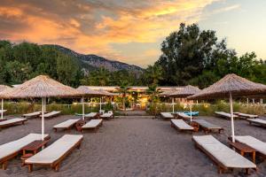 a group of benches and umbrellas on a beach at Villa Lukka in Cıralı