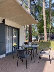 eine Terrasse mit einem Tisch und Stühlen auf einer Terrasse in der Unterkunft Apartament w Międzywodziu z parkingiem in Międzywodzie