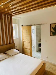 a bedroom with a bed and a bathroom at Suite 24 Appart'hôtel-3 étoiles in Le Creusot