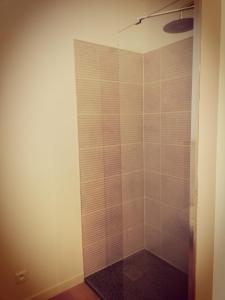 een badkamer met een douche en een glazen deur bij Suite 24 Appart'hôtel-3 étoiles in Le Creusot