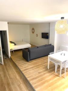 a living room with a couch and a bed at Suite 24 Appart'hôtel-3 étoiles in Le Creusot +24 photos