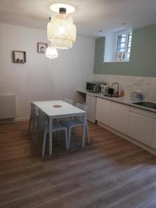 a kitchen with a table and chairs in a room at Suite 24 Appart'hôtel-3 étoiles in Le Creusot