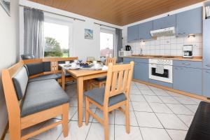 a kitchen and dining room with a table and chairs at Ferienwohnung Weitblick in Holtgast