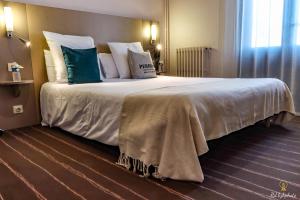 Postel nebo postele na pokoji v ubytování Logis Hôtel du Parc