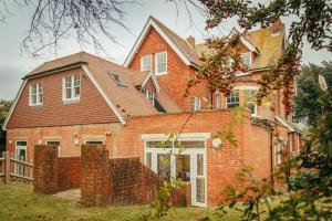 a red brick house with a roof at Ravelston Grange - stylish, spacious garden flat in Old Town