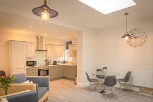 a living room and kitchen with a table and a couch at Ravelston Grange - stylish, spacious garden flat in Old Town
