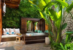 a bathroom with a bath tub in a garden at Villa Lukka in Cıralı