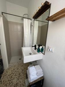 a bathroom with a sink and a mirror at Macallè Suite Noto, charme e relax con giardino in Noto