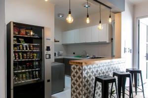 a kitchen with a counter with stools and a refrigerator at Buongiorno B&B Hotel in Marcos Juárez
