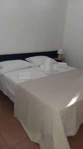 1 cama blanca grande con 2 toallas en Appartamenti La Villa Peschici en Peschici