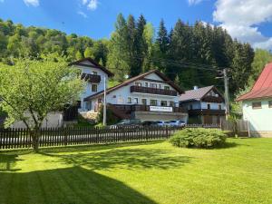 a large house with a fence in a yard at Penzión Liezky in Mýto pod Ďumbierom