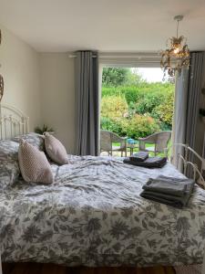a bedroom with a bed and a large window at New Forest Chalet in Ibsley