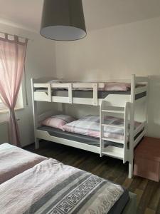 2 literas blancas en un dormitorio con lámpara en Ferienwohnung am Tor zum Thüringer Wald en Plaue