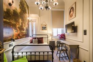 a bedroom with a bed and a table and a chandelier at BpR Violet Noir Apartment with A/C in Budapest