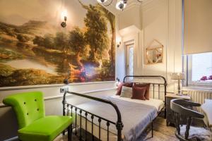 ブダペストにあるBpR Violet Noir Apartment with A/Cの絵画、ベッド1台、椅子が備わるベッドルーム1室