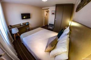 Postel nebo postele na pokoji v ubytování Logis Hôtel du Parc