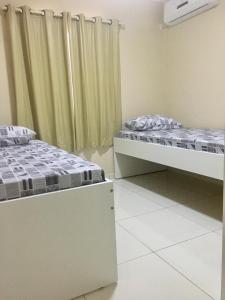 dwa łóżka w pokoju z oknem w obiekcie Flats Integração w mieście Petrolina