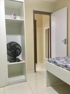 a room with a bed and a fan on a shelf at Flats Integração in Petrolina