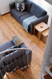 een woonkamer met een blauwe bank en een tafel bij CITY CENTRE APARTMENT with Free Secure Underground Parking in Glasgow