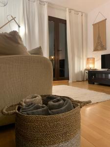 a basket of towels sitting on the floor next to a couch at Ático con vistas increibles a pie de pista y garaje incluido in Sierra Nevada