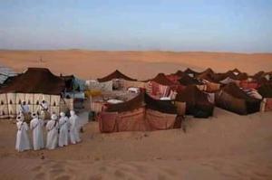 Eine Gruppe von Menschen, die in der Wüste stehen in der Unterkunft Moha House in Merzouga
