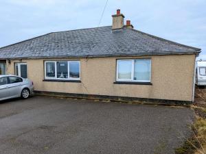 a house with a car parked in front of it at Hamnavoe John o Groats Hostel in John O Groats