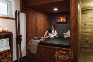 a woman sitting on a bed in a sauna at Haus Bernhard in Ramsau am Dachstein