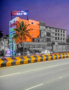 a building with a palm tree in front of a street at RedKEY Inn Bangalore Airport - Pick up & Drop Available 24x7 in Yelahanka