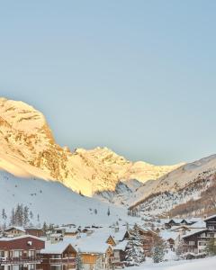 a town in the snow with mountains in the background at Airelles Val d'Isère in Val dʼIsère