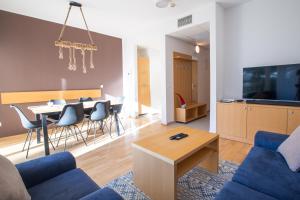 a living room with a blue couch and a table at Pohorje Fox duplex apartment in Maribor
