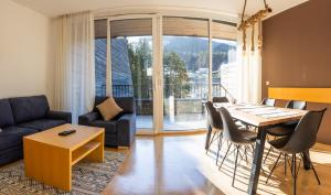 マリボルにあるPohorje Fox duplex apartmentのテーブルと椅子とソファのあるリビングルーム