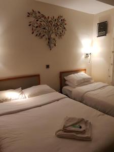 una camera d'albergo con due letti e asciugamani di Linden Tree a Gloucester