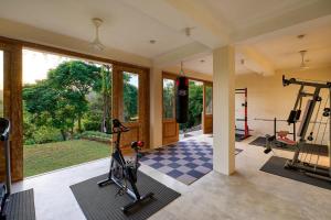 a gym with exercise equipment and a large window at The Divine Villa in Talpe