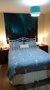 a bedroom with a bed with a blue comforter and two lamps at Hamnavoe John o Groats Hostel in John O Groats