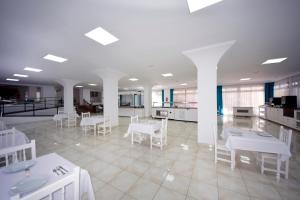 a dining room with white tables and white chairs at Skyview Hotel Tenerife in Puerto de la Cruz
