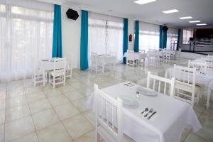 a dining room with white tables and white chairs at Skyview Hotel Tenerife in Puerto de la Cruz