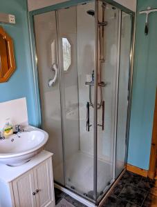 a bathroom with a shower and a sink at Hamnavoe John o Groats Hostel in John O Groats