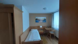 een ziekenhuiskamer met een bed en een bureau bij Landhotel Wiesenhof in Heroldstatt +10 foto's
