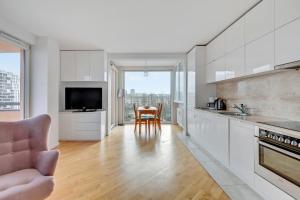 kuchnia z białymi szafkami i stołem z krzesłami w obiekcie Comfort Apartments Horyzonty w Gdańsku +11 zdjęć