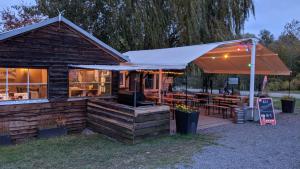 een restaurant met een parasol en tafels en stoelen bij Gemütliche Ferienwohnungen in Friedland Ortsteil Cosa in Friedland