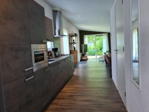 a kitchen with wooden floors and a long hallway at de4SeiZoentjes in Schoonebeek