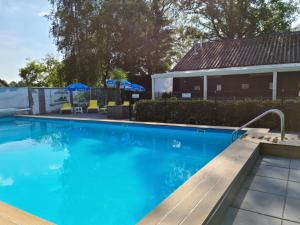 a swimming pool with a bench next to a house at de4SeiZoentjes in Schoonebeek