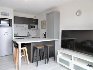 a kitchen with a large white counter and stools at Appartement YOUN - à 500 m de la plage WIFI in Sarzeau +7 photos