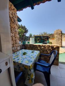 una mesa y sillas en un patio con mesa y vistas a la piscina en Case Pescatori Villette, en Lampedusa