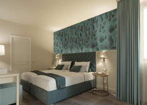 a bedroom with a large bed with a blue wall at PFA Hotel Viareggio in Viareggio
